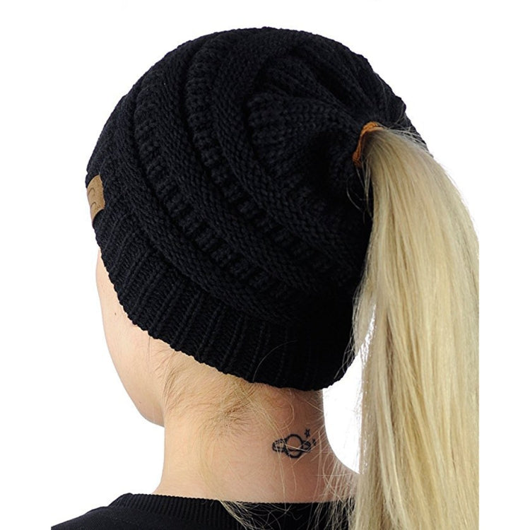 Black knitted ponytail cap beanie with ribbed texture and open back for ponytail