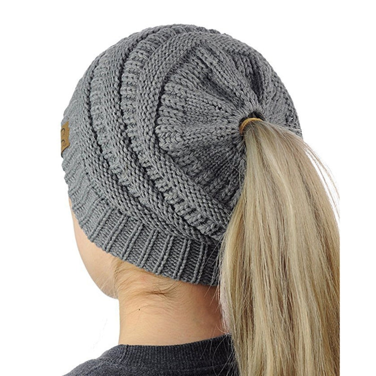 Marled cable-knit ponytail beanie in grey with back opening for a ponytail.