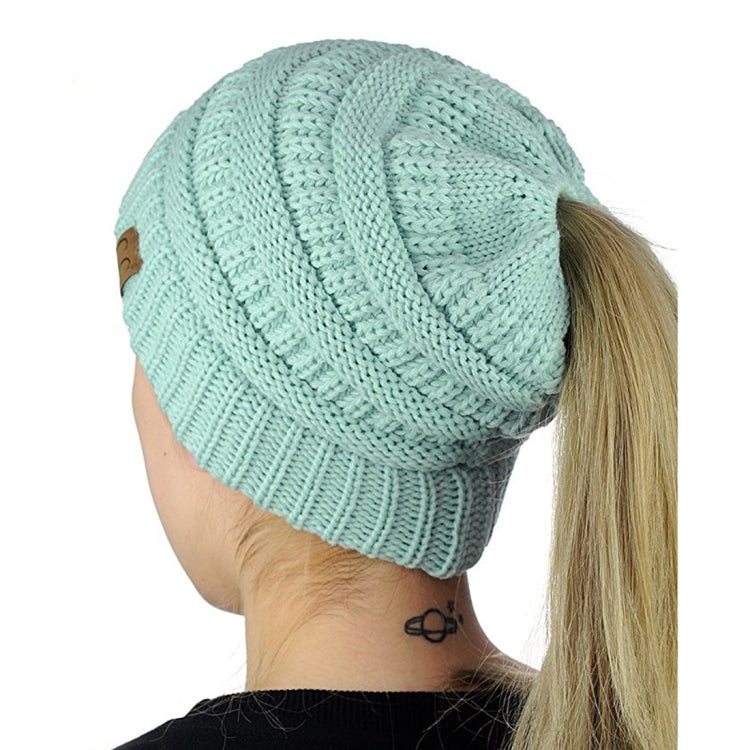 Cable-knit ponytail cap beanie in light aqua with back opening for ponytail hair.