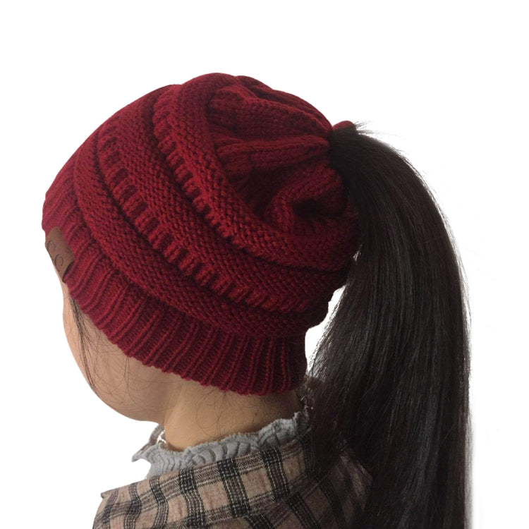 Burgundy knit ponytail beanie hat with ribbed brim and folded cuff