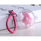 Clear hollow plastic ball ornament with pink rose inside and pink braided strap