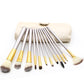 Open beige makeup brush pouch with silver handles, gold trim, and brush heads visible