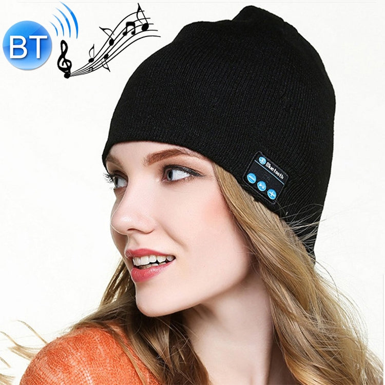 Black knit beanie with built-in Bluetooth control panel, worn by a woman in profile.