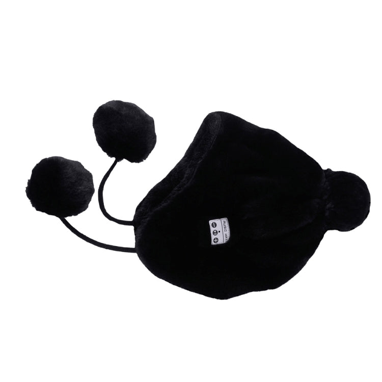 Black plush winter ear-muff hat with round pom-poms and small control panel patch