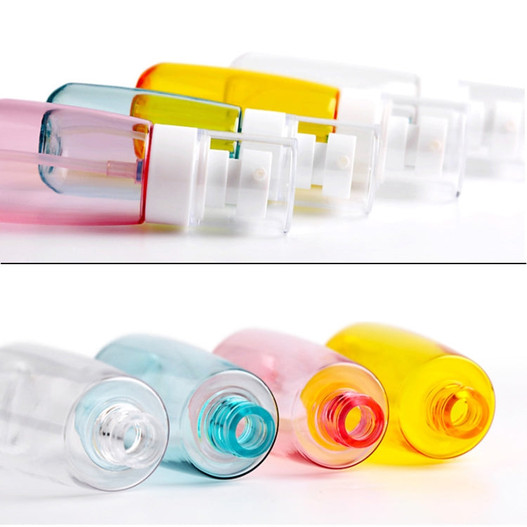 Side view of multiple translucent travel bottles with white pumps and colored bodies