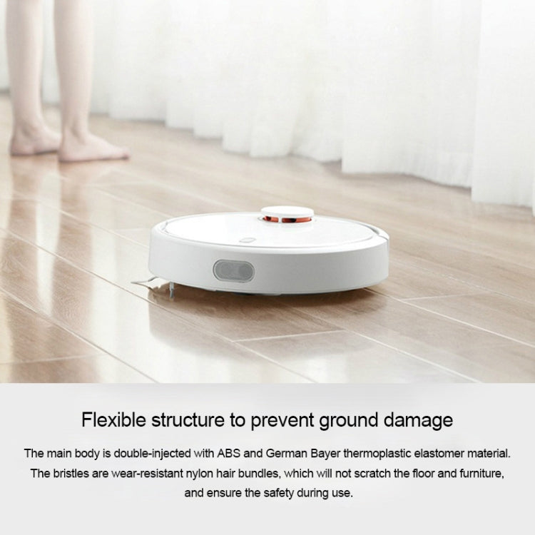 White robotic vacuum sweeping on floor with top status light
