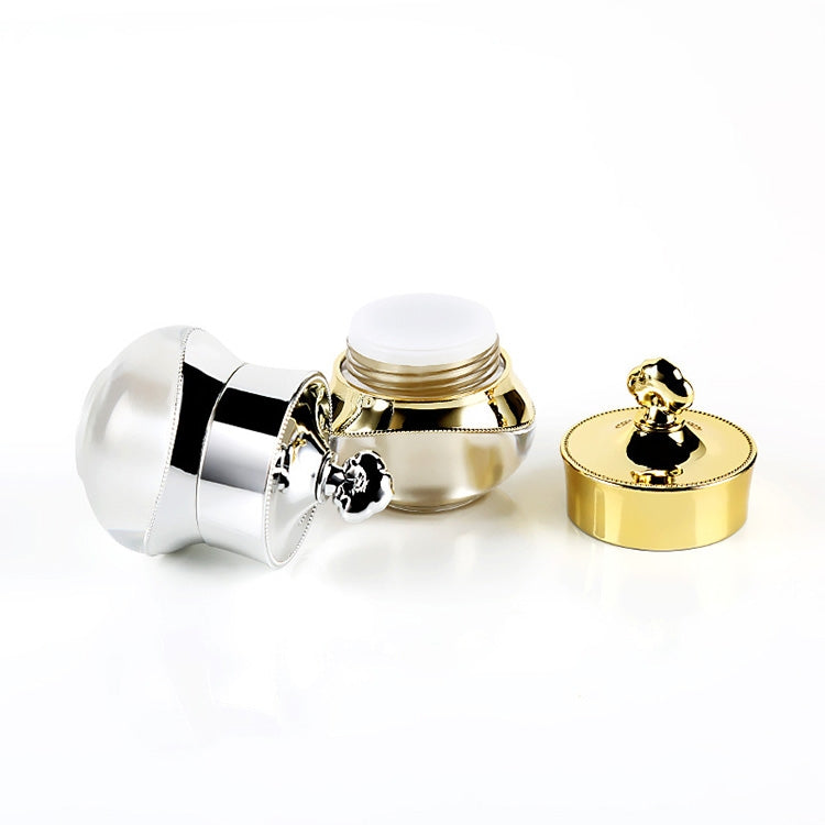 Acrylic travel container open with gold lid and silver base, showing closure
