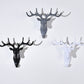 Three deer head wall hooks in dark, gray, and white with four antlers
