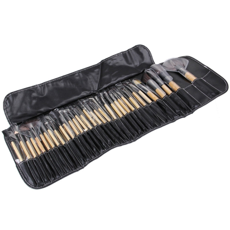 Rolled PU leather case holding 32 makeup brushes with light wood handles and bristles