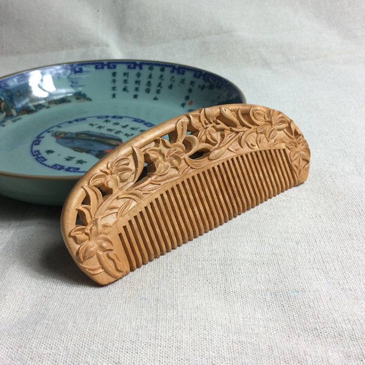 Wooden hair comb with carved floral border and evenly spaced straight teeth