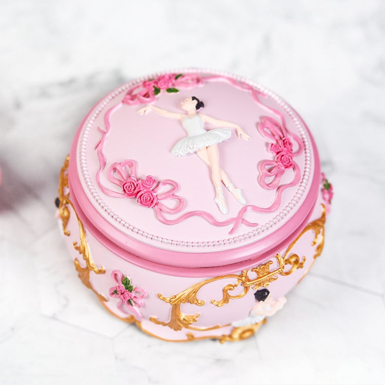 Pink oval music box with ballerina silhouette and decorative rose details