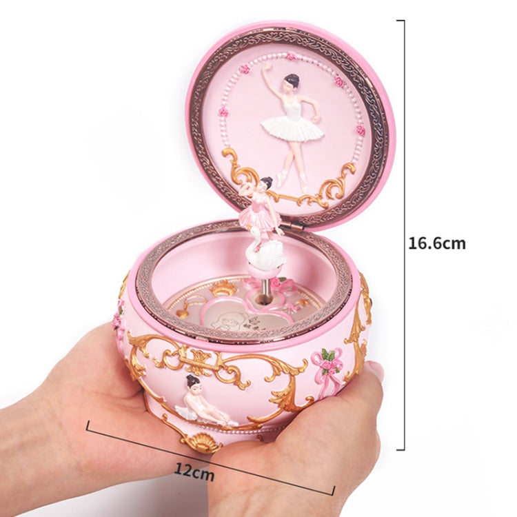 Pink rotating music box with ballerina stand; open lid shown in hand