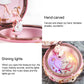 Open pink music box with hand-carved ballerina scene and glowing interior lights