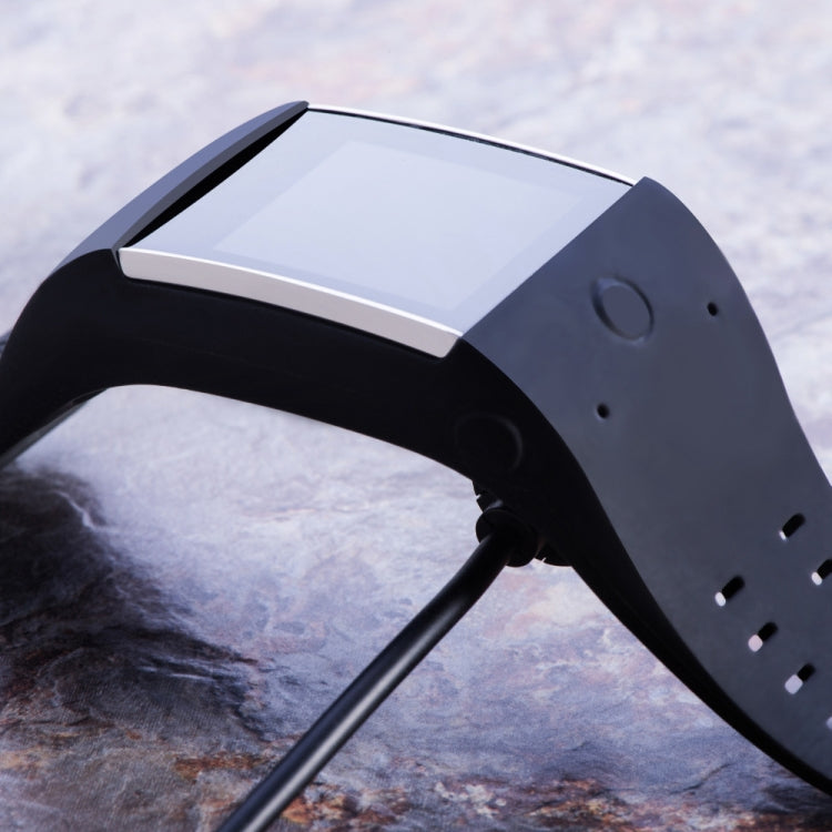 Black charging cable connected to device port on sport watch strap