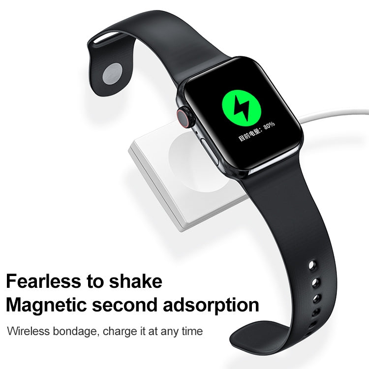 Black magnetic wireless charger dock beside smartwatch band, close-up
