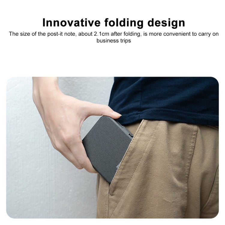 Gray foldable wireless charger tucked into fabric case, held by hand