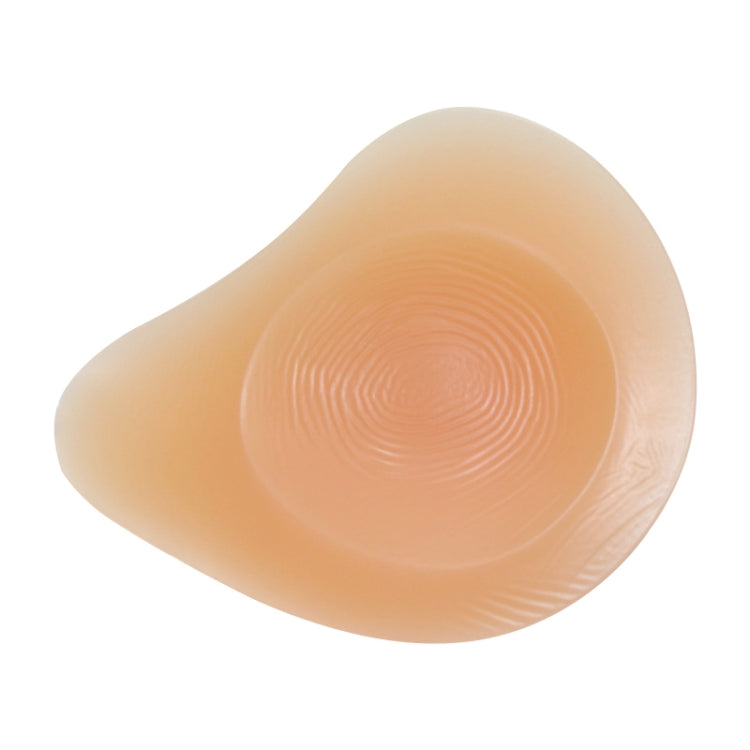 Silicone breast pad with spiral-textured nipple area, smooth light peach curve.
