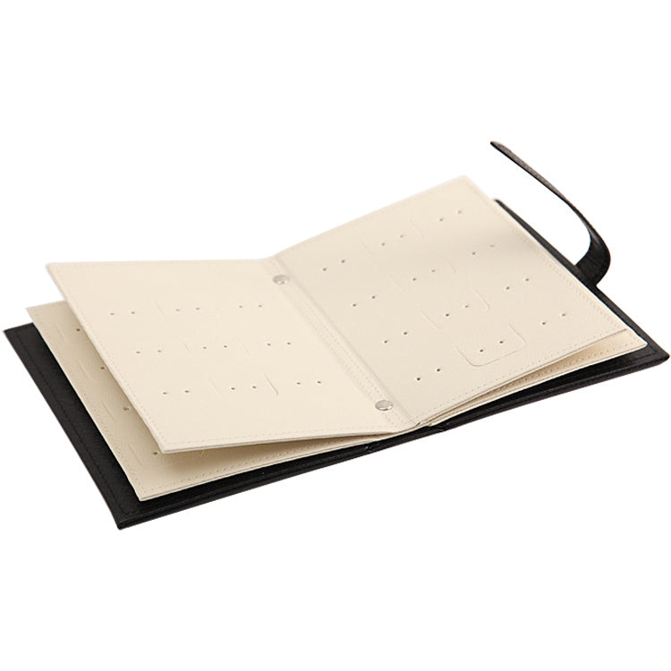 Cream book-shaped jewelry display rack with strap and earring holder insert