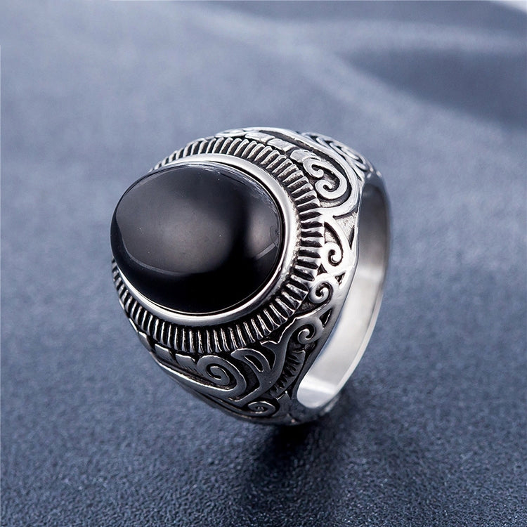 Men’s titanium steel ring close-up with dark oval gemstone and engraved silver scrollwork