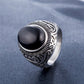 Men's titanium steel ring front close-up with black oval stone and carved silver details
