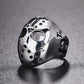 Angle view skull mask ring with flame-like emblem, open eye cutout, studs