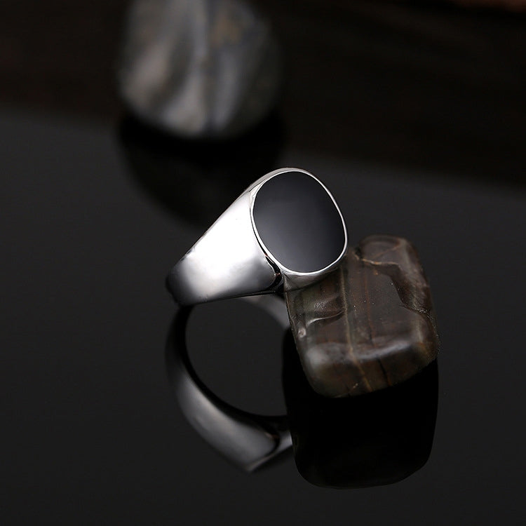 Silver-tone ring with black oval top, dramatic side angle