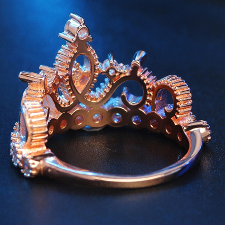 Rose gold crown-shaped zircon ring side view with openwork center and prong-set stones