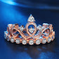 Rose gold crown-shaped zircon ring with central round stone and a row of clear stones