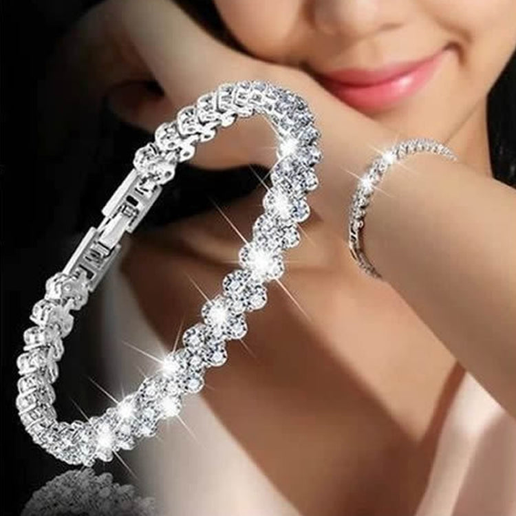 Silver crystal tennis bracelet with round faux diamond stones, worn on wrist
