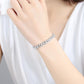Silver crystal tennis bracelet on wrist, row of round rhinestones with clasp