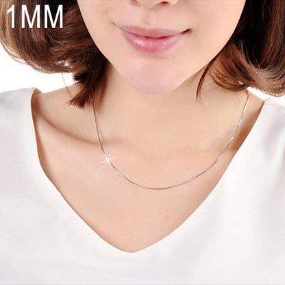 Silver snake-bone chain necklace on a model’s neck, thin 1mm links