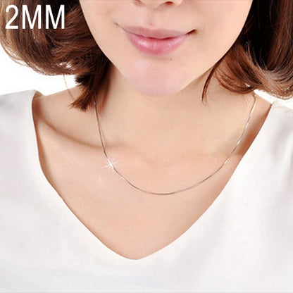 Silver snake-bone chain necklace, 2mm wide, resting on a model’s neckline