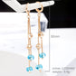 Long gold-tone crystal tassel earrings with blue drop beads
