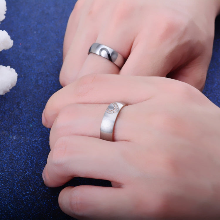 Two hands wearing matching titanium steel rings with heart diamond accents