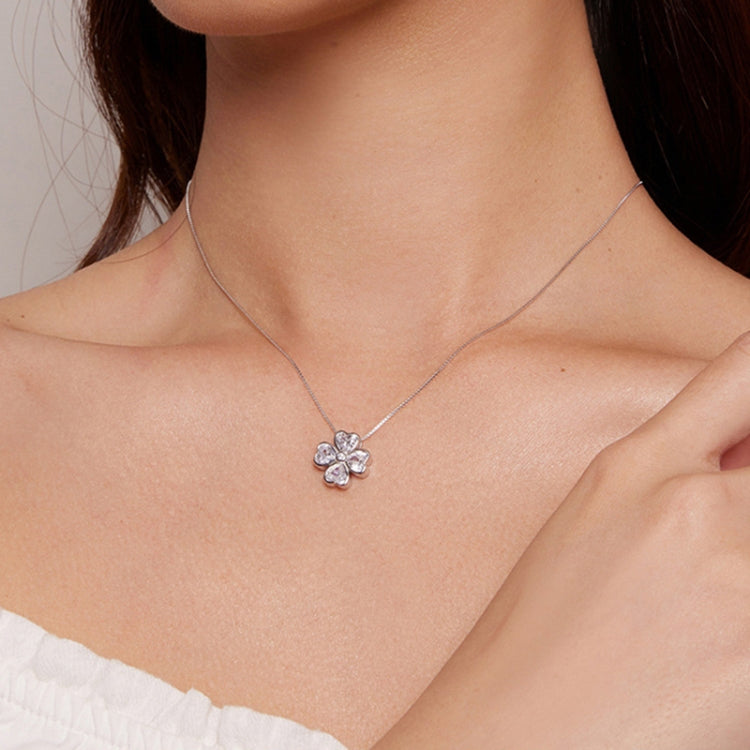 Lucky clover pendant necklace on model with small four-petal pendant and stone center