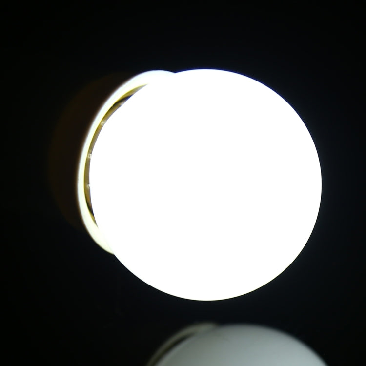 Glowing LED E27 globe light bulb with white light and visible silver base