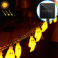 Warm yellow-glowing ghost-shaped LED string lights on an outdoor cord