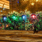 Colorful glowing solar stake lantern lights among green plants