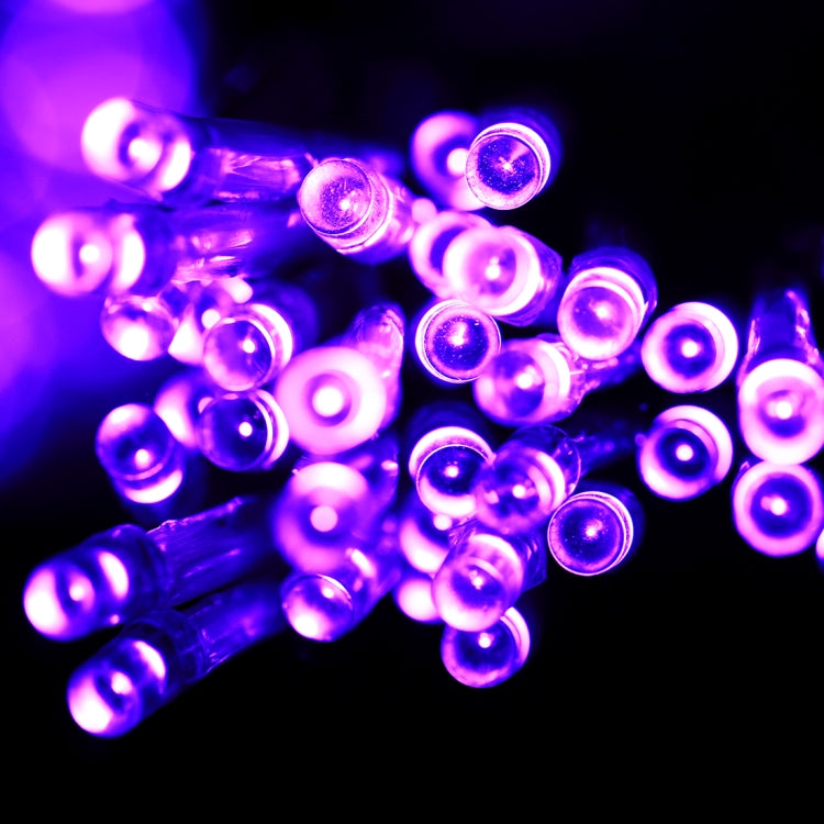 Purple LED string light bulbs glowing with round caps on clear wire