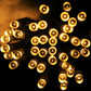 Warm white LED string light bulbs glowing with round caps on cable
