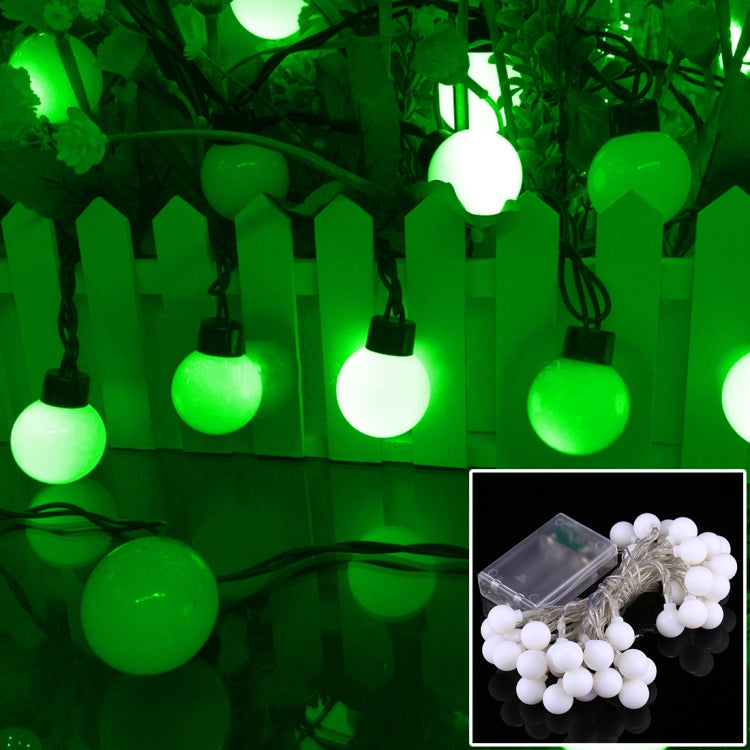 Green LED globe string lights with round lit bulbs on a hanging wire strand