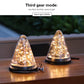 Two solar conical garden lights on a wooden surface, warm glowing cone bulbs