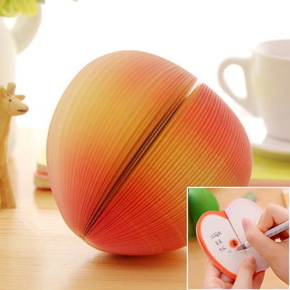 Peach-shaped note sticker with orange-red pleated paper design, plus close-up writing insert