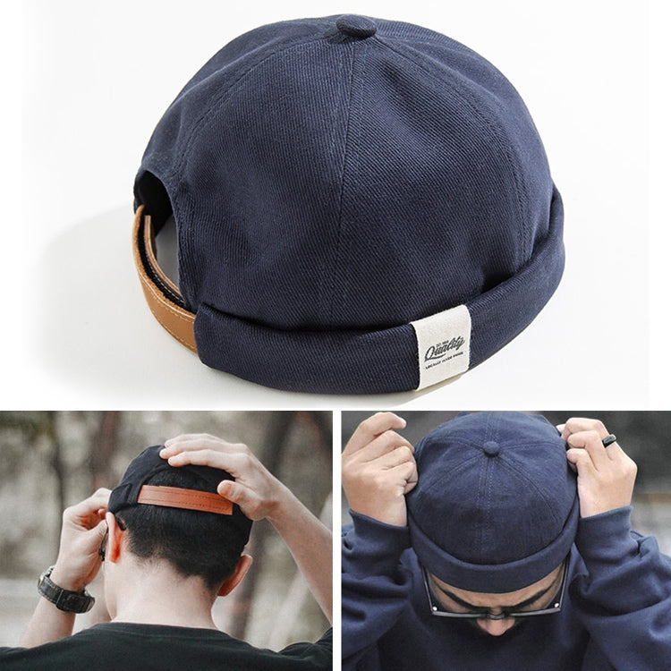 Navy cotton sailor-style beanie hat with rolled cuff and brown faux-leather band