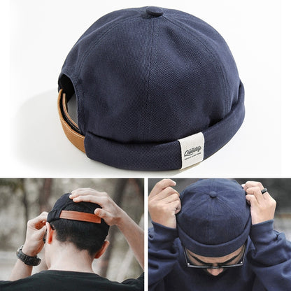 Navy cotton sailor-style beanie hat with rolled cuff and brown faux-leather band