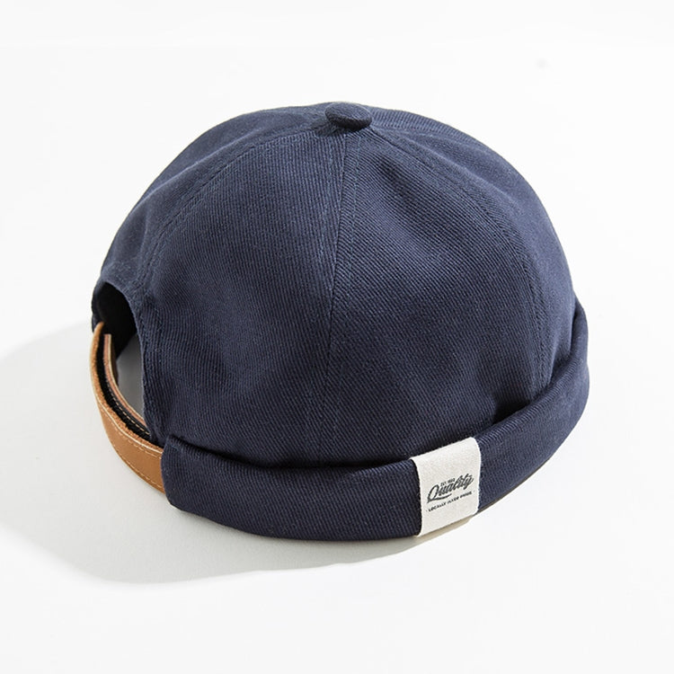 Navy sailor-style beanie cap with rolled cuff and brown band detail at side