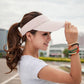 Light beige visor cap with curved brim and breathable textured fabric top.