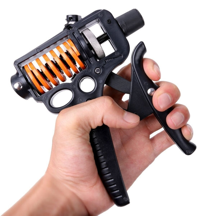 Adjustable hand grip strength tool held in hand, black frame and orange spring