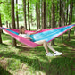 Pink and blue parachute hammock sling with one person relaxing outdoors