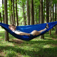 Dark blue parachute hammock swing with one person relaxing outdoors